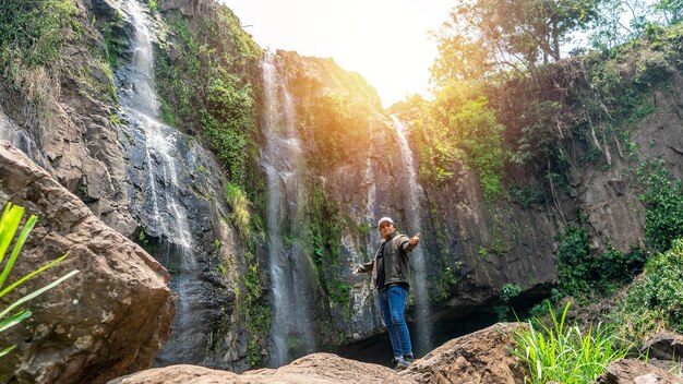 Latino man in front of a waterfall exploring the mountainous area of Matagalpa Nicaragua