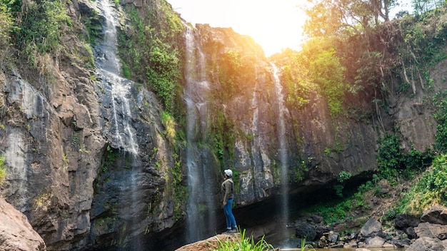 滝の前で自己発見と自然との再会を旅するラテン系男性