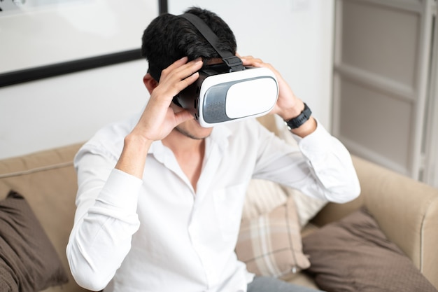 Latino man on sofa with virtual reality glasses