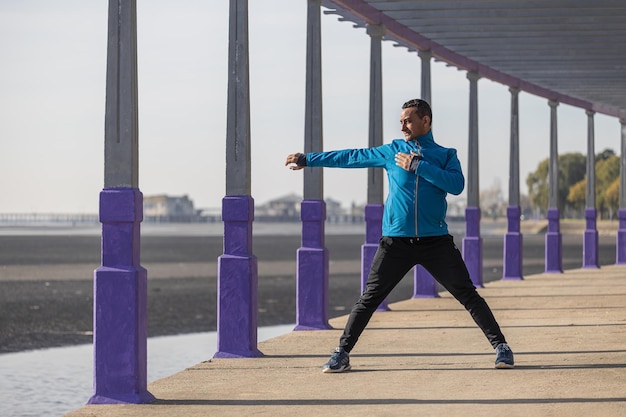 Latino runner stretching in a pergola in a public park