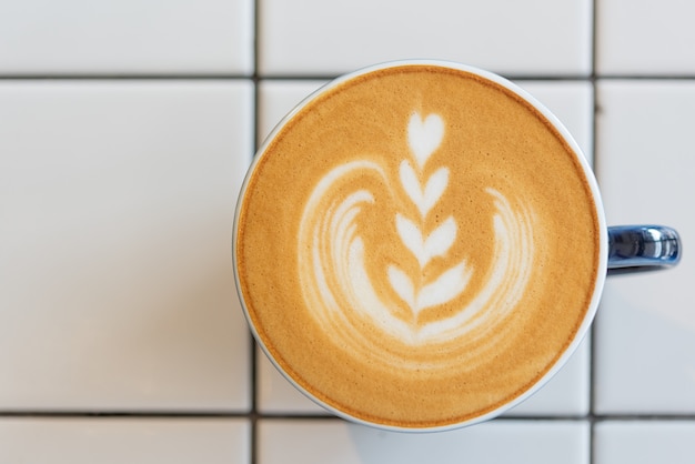 Tazza di caffè di arte del latte sulla tavola bianca, vista superiore