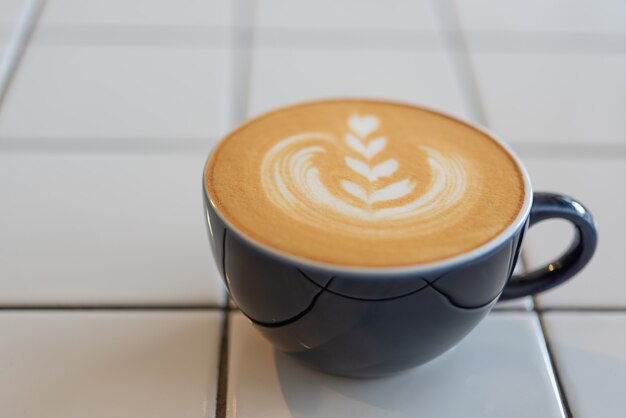 Latte art coffee cup on white table