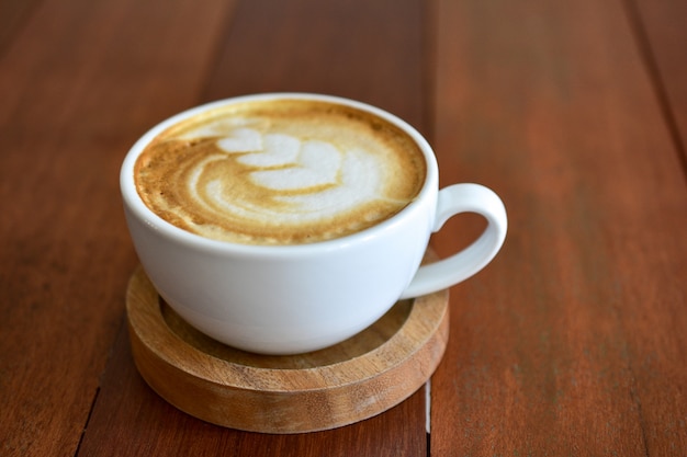 コーヒータイムに木製のテーブルの上のコーヒーカフェラテアート