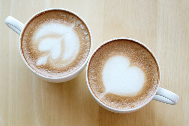 latte art coffee on wooden table background.