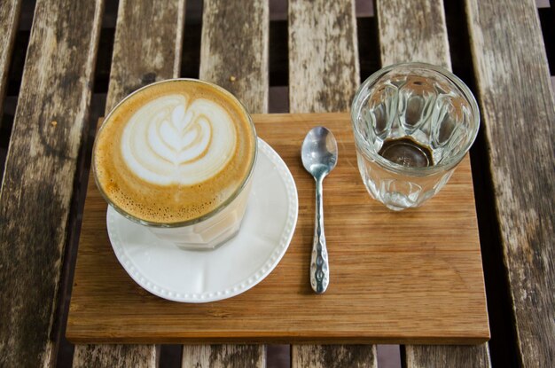 Latte art warme koffie op houten tafel in coffeeshop en restaurant bij Tak Thailand