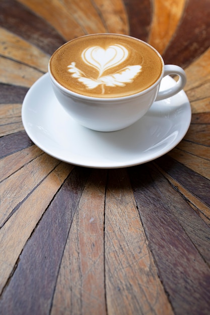 Latte art in a white coffee mug on a wooden table