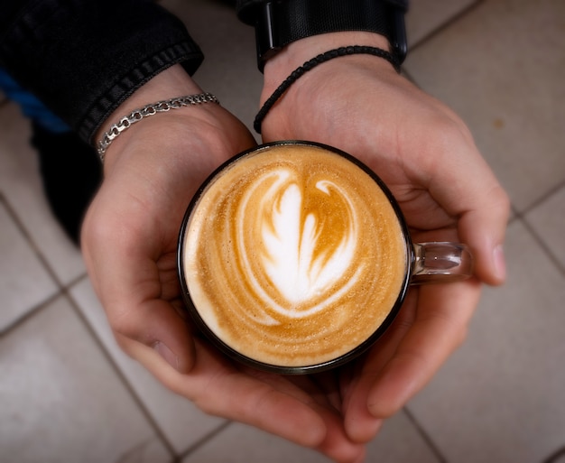 Latte coffee with milk in hands