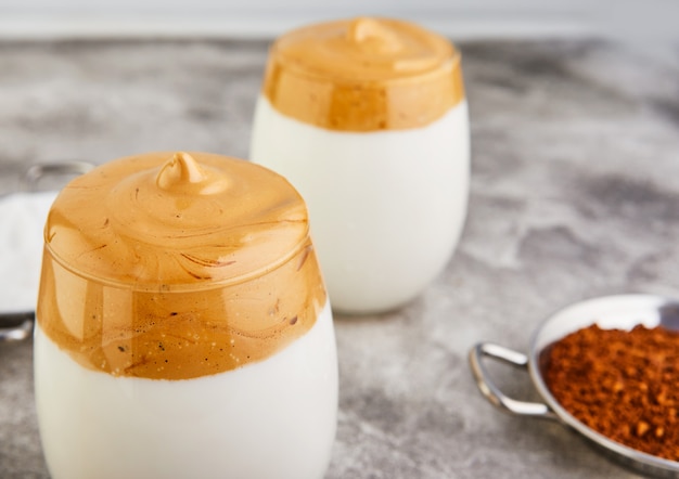 Latte espressos with coffee foam in tall glass and milk