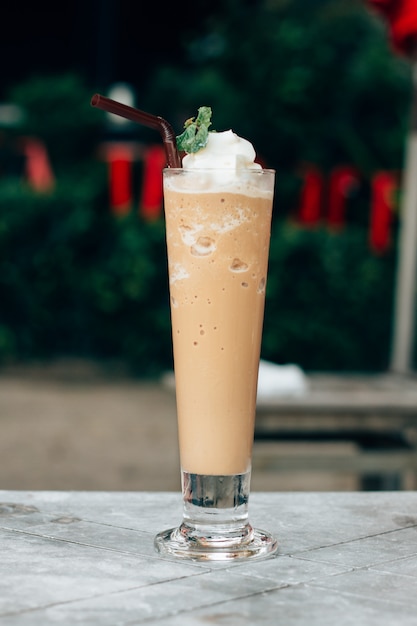 Foto latte gemengd met slagroom, uitknippad. ijskoffieblender in een glas.