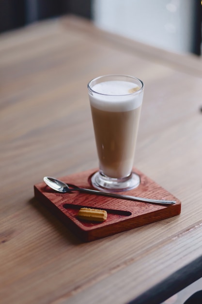 Latte in a high glass on a wooden table