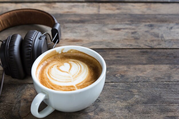 latte koffiekopje en hoofdtelefoon op houten tafel