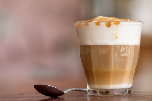 Latte macchiato coffee on wooden desk in coffee shop