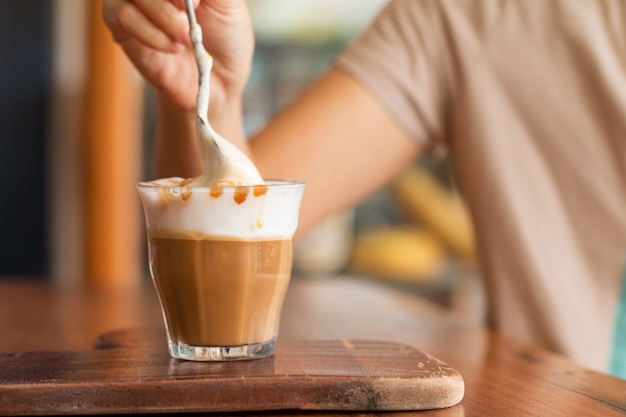 Latte macchiato coffee on wooden desk in coffee shop