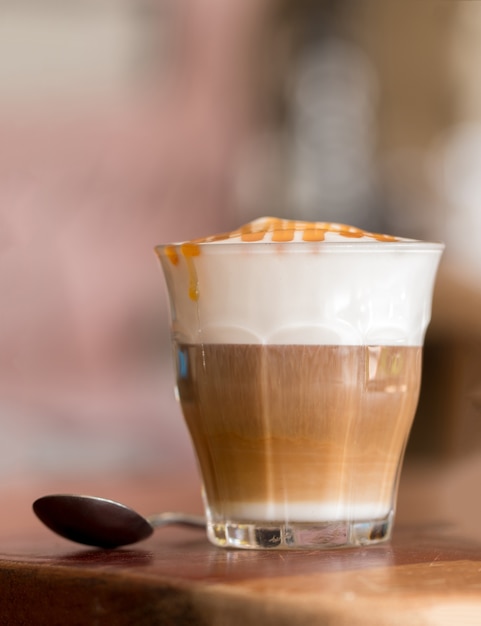 Latte macchiato coffee on wooden desk in coffee shop