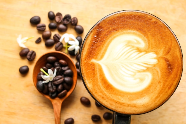 Латте Молочный кремовый цветок Деревянная ложка кофейного зерна Фон