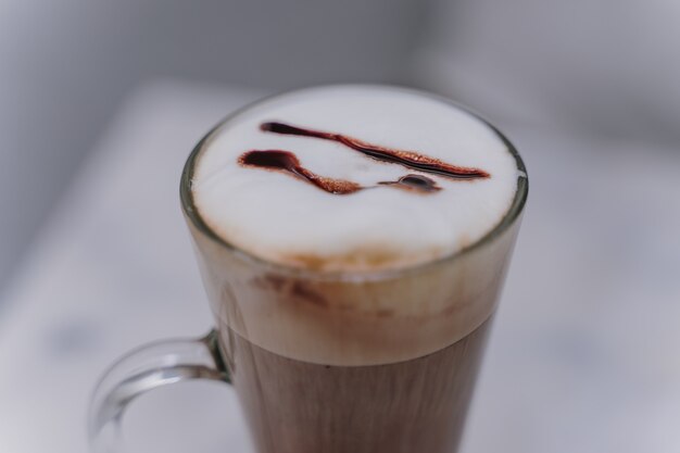 Latte of Cappuccino met schuimige schuim, koffiekopje bovenaanzicht op tafel in café.