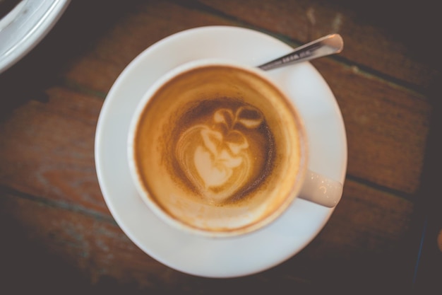 Latte warme koffie met melkschuimkunst op een houten tafel