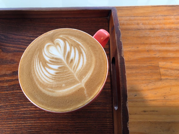 A latte with a wood grain table