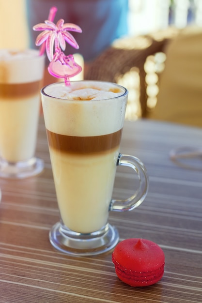 Lattekoffie met makaron op de tafel in de straat, terras, terras, zonsondergang