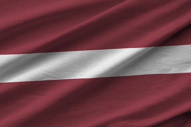 Latvia flag with big folds waving close up under the studio light indoors The official symbols and colors in banner