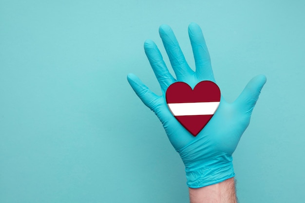 Latvia medical health heart nurse hand holding country heart flag