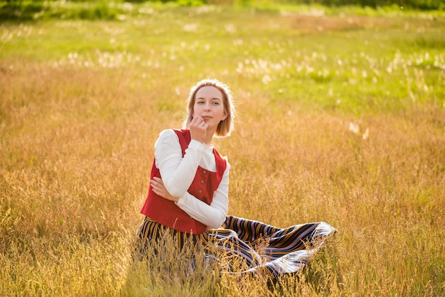 Latvian woman in traditional clothing in field