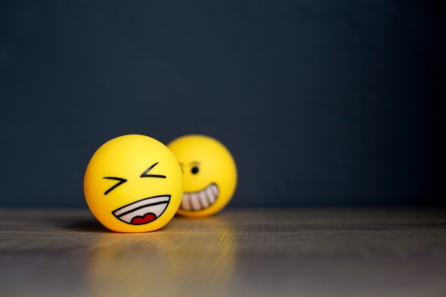 Premium Photo | Laugh emoticon and blurry smiley emoticon on black  background