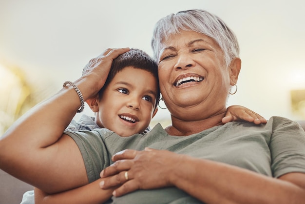 Laugh grandmother and grandchild on a sofa smile and happy love and family while bonding in their home Relax grandma and child embrace funny and joke on a couch loving and sweet in living room