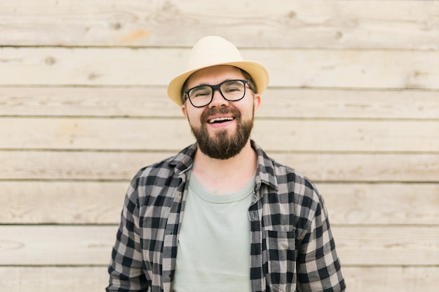 Uomo attraente che ride che indossa il cappello su fondo di legno emozione e concetto di vacanze di viaggio di vacanza