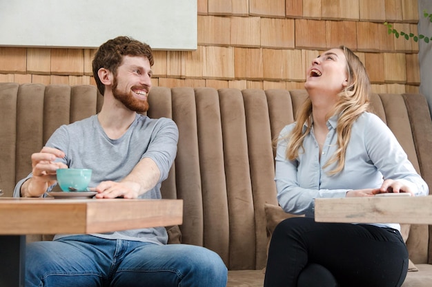 Photo laughing couple on date in coffee shop