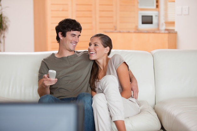 Laughing couple watching funny movie together