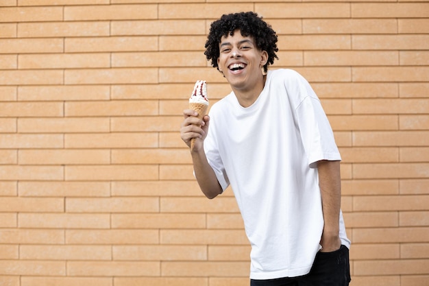 Laughing curly haired AfricanAmerican guy stained on nose with white ice cream