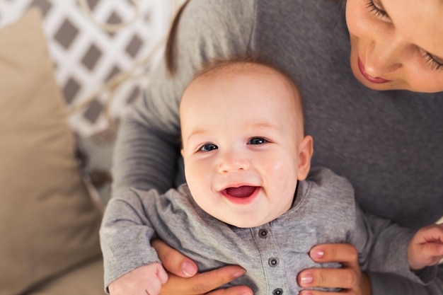 彼の母親と一緒にかわいい男の子を笑う