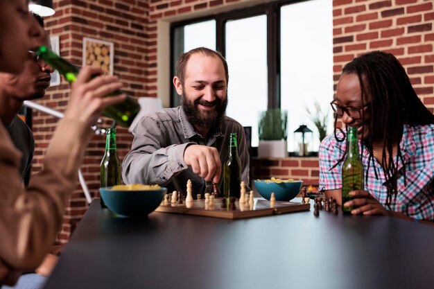 Pensive african american man thinking about next chess move while sitting  at table. Stock Photo by DC_Studio