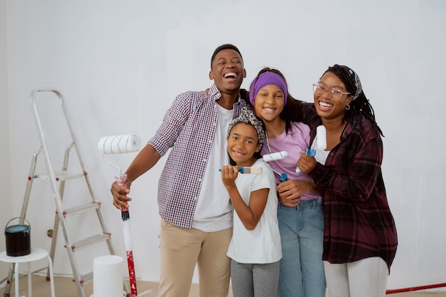 A laughing family goofs off during an apartment renovation children and their parents