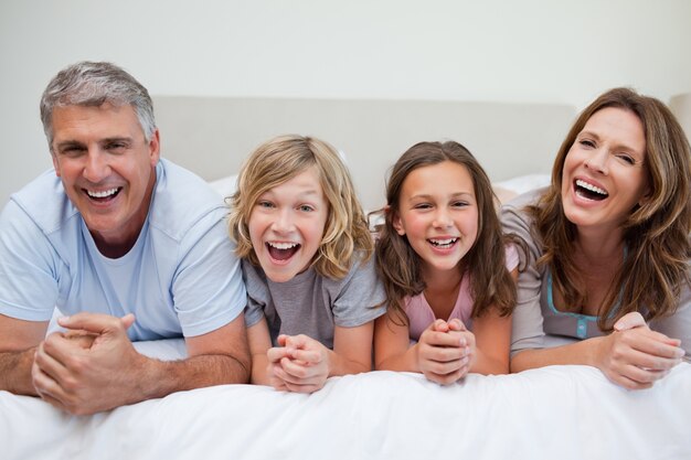 Laughing family lying on the bed