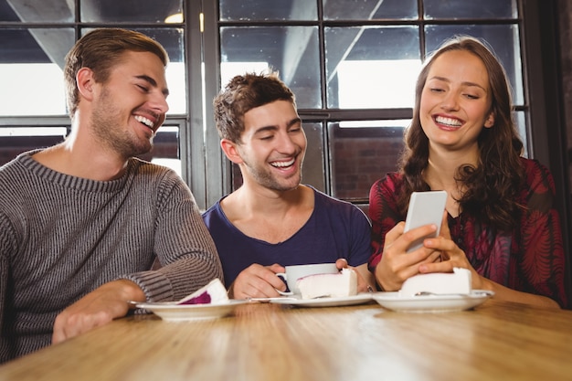 Laughing friends looking at smartphone