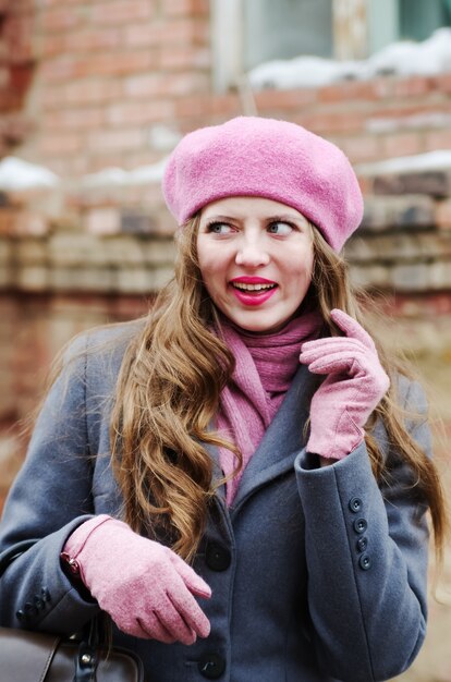 Laughing girl in a gray coat and pink beret