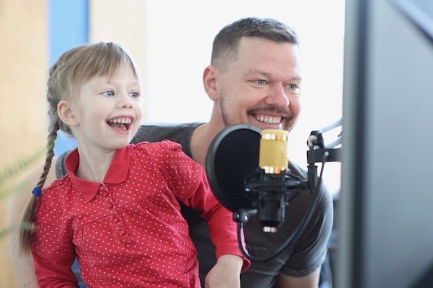 Laughing girl and man sing song into microphone closeup