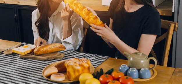 Laughing group of diverse young woman hanging out at home together and eating pizza