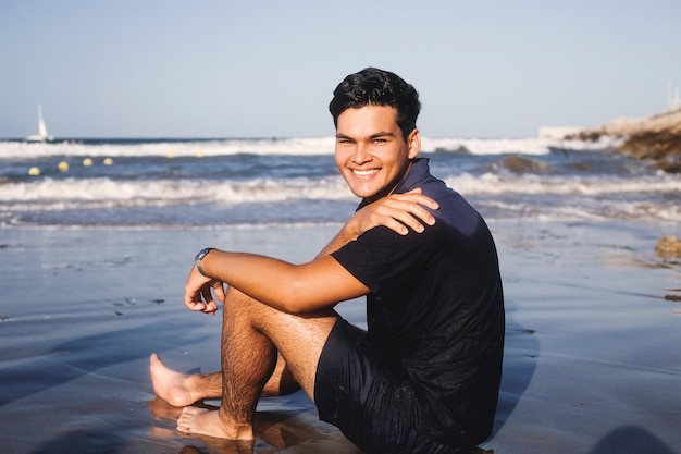 Foto uomo carino che ride sulla riva del mare