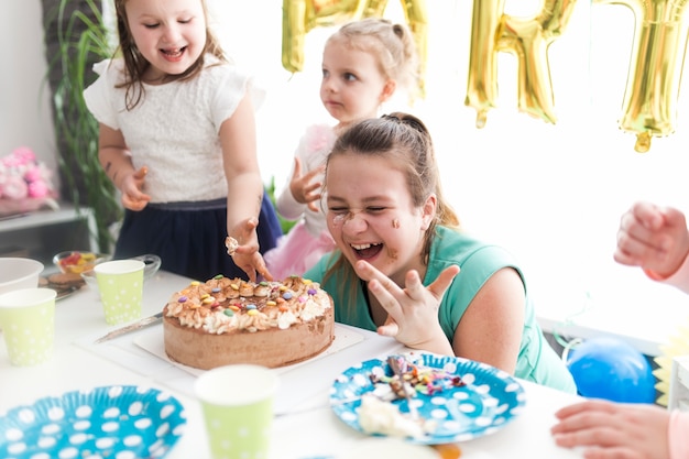 写真 子供とティーンエイジャーのケーキを笑う