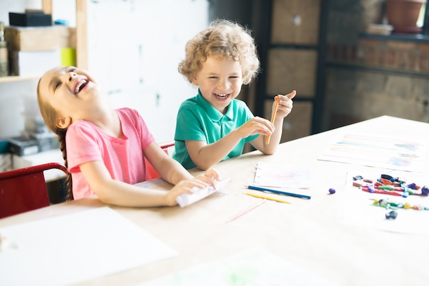 Laughing Kids Drawing at Table