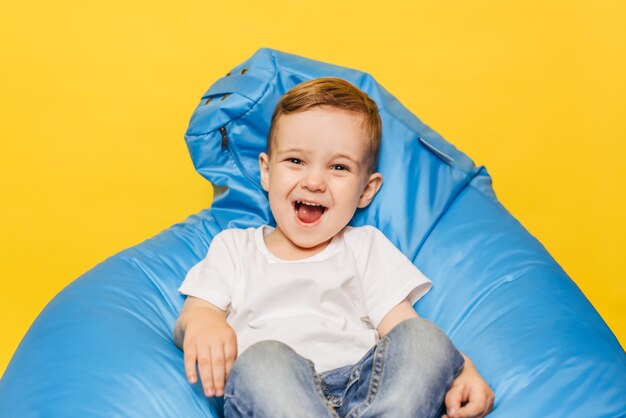 Laughing little boy on a yellow background