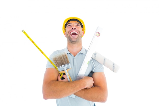 Laughing manual worker holding various tools