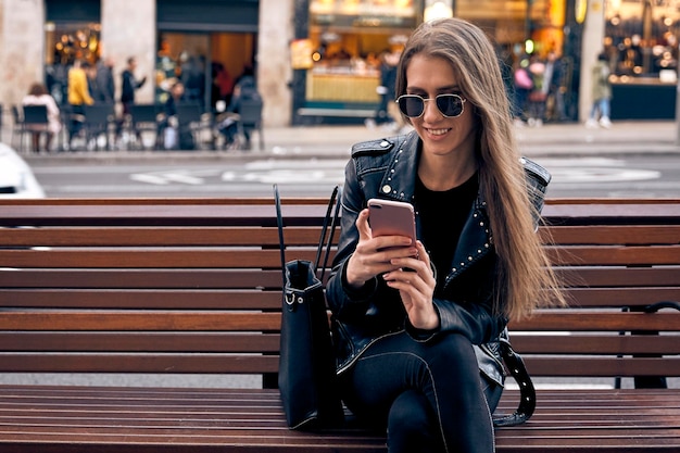 Photo laughing pretty girl using her phone