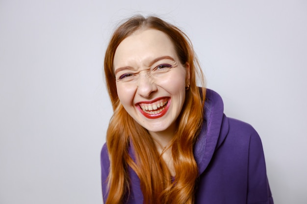 Laughing redhead girl in purple hoodie