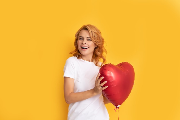 Laughing redhead lady with romantic gift of party balloon. be my valentine