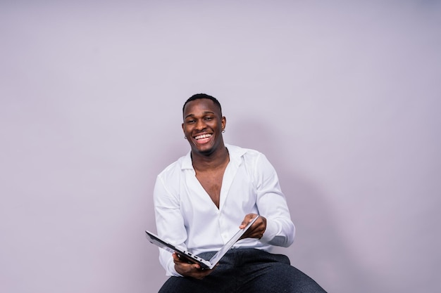 Laughing single handsome young african man over red yellow background with copy space