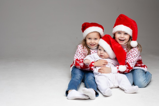 Laughing sisters with baby brother at xmas